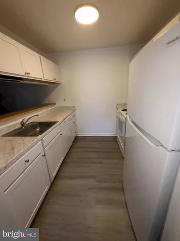 a kitchen with white cabinets and white appliances