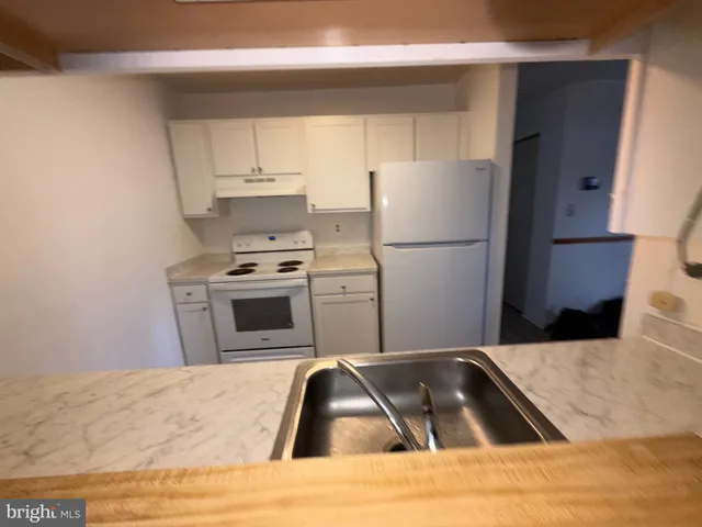 a kitchen with a refrigerator sink and cabinets