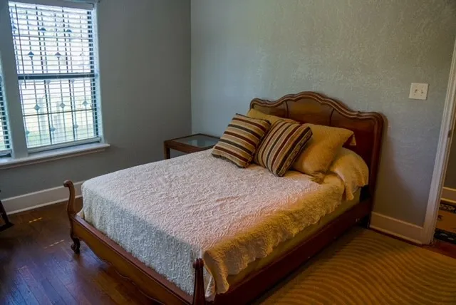 a large bed sitting in a bedroom next to a window