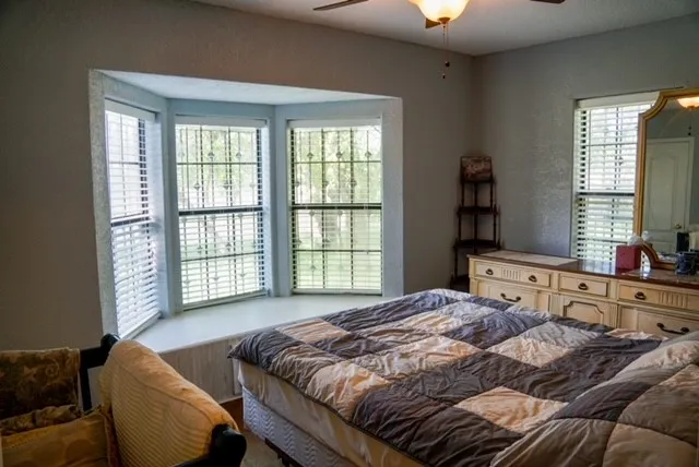 a bedroom with a bed and a couch with window