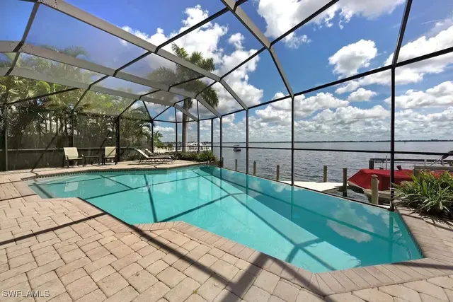 a view of a patio with table and chairs with wooden floor and fence