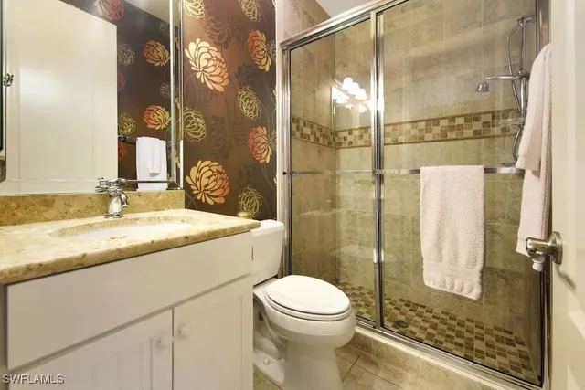 a bathroom with a granite countertop sink a toilet and a mirror