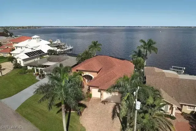 an aerial view of a house with a yard and lake view