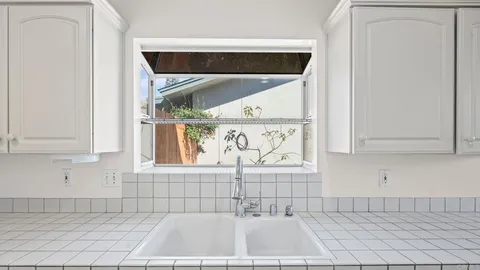 a view of a sink and dishwasher with wooden floor