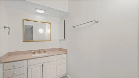 a bathroom with a granite countertop sink mirror and vanity