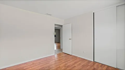 a view of an empty room with wooden floor
