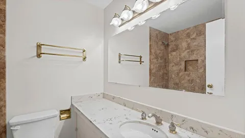 a bathroom with a sink a toilet and shower