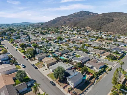 a front view of a house with a yard and mountain view