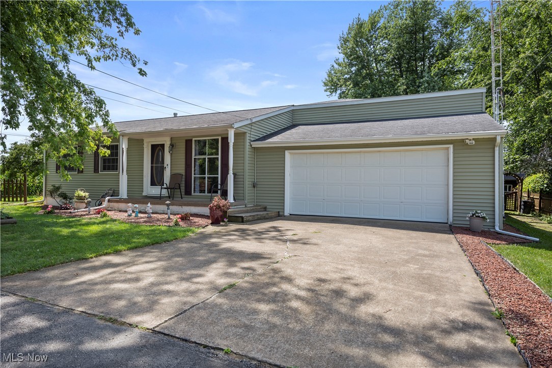 319 Ironwood Road Huron, OH 44839 - Photo 1 of 32 View of front of home with an attached garage, a front lawn, a porch, concrete driveway, and a shingled roof
