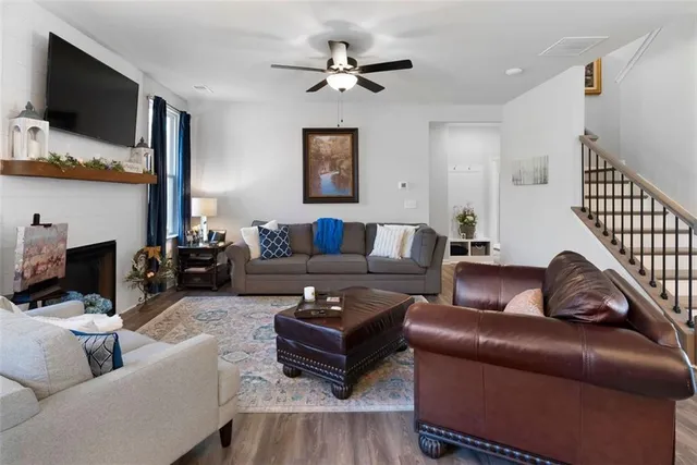 a living room with furniture ceiling fan and a flat screen tv