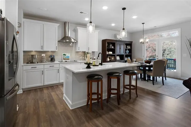 a kitchen with a sink a stove a dining table and chairs