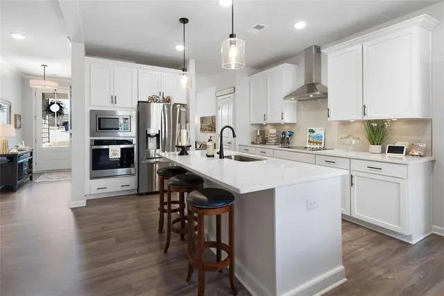 a kitchen with a sink stainless steel appliances and white cabinets