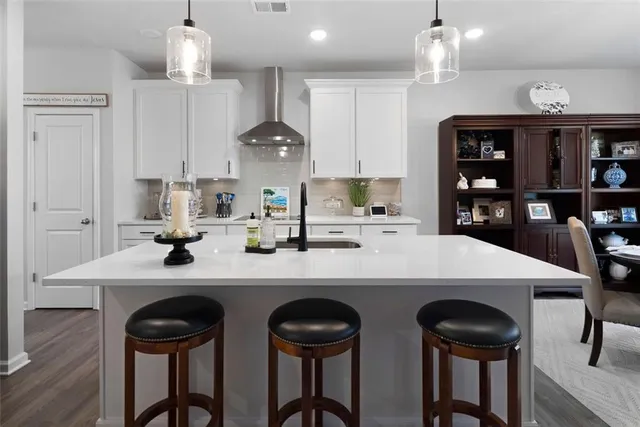 a kitchen with stainless steel appliances a table chairs and a refrigerator