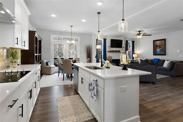 a large kitchen with kitchen island a sink a counter top space a large window and stainless steel appliances