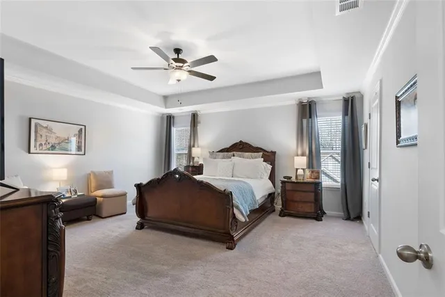 a spacious bedroom with a bed and a chandelier