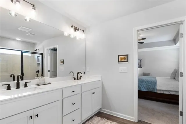 a en suite bathroom with double sink a large mirror and shower