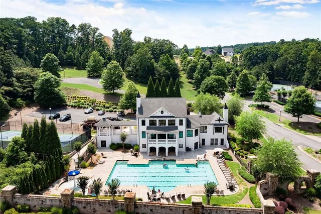 a view of a swimming pool with lawn chairs and plants