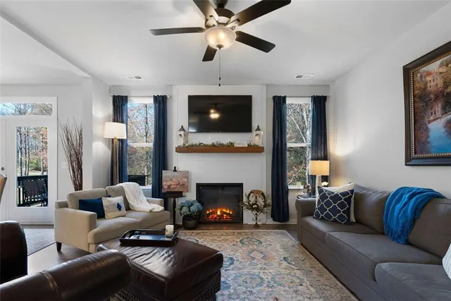 a living room with furniture a flat screen tv and a fireplace