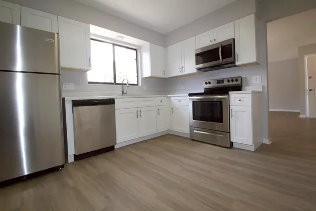 a kitchen with stainless steel appliances a refrigerator microwave and sink