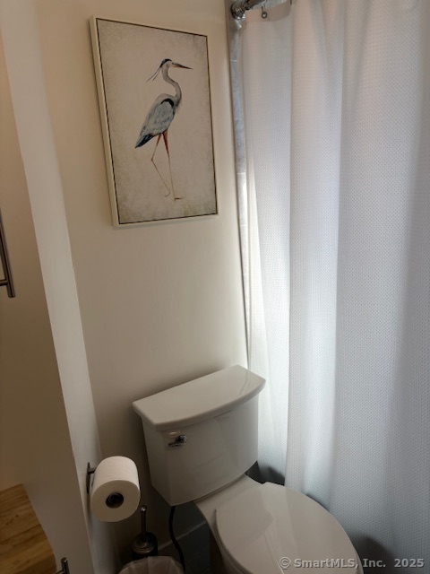 1 Cannon Square Stonington, CT 06378 - Photo 20 of 21 a white toilet sitting next to a shower curtain