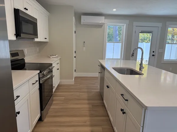 a kitchen with granite countertop a sink and a stove top oven