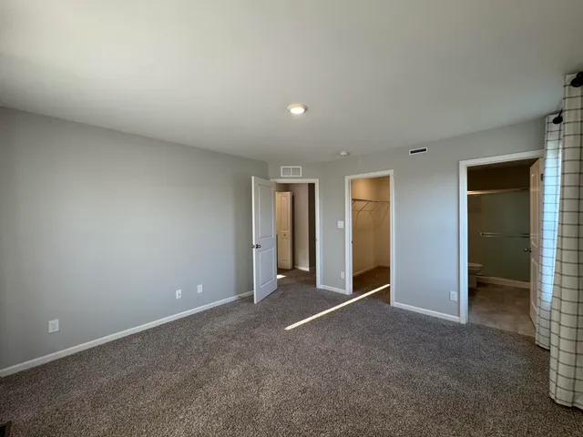 an empty room with closet and wooden door