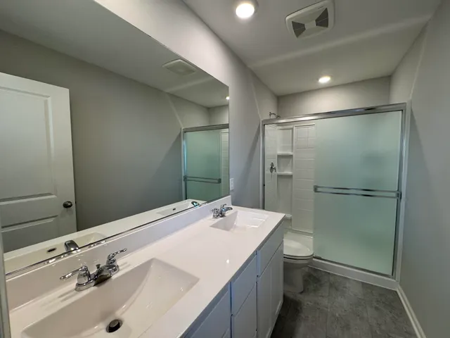 a bathroom with a sink a toilet and shower