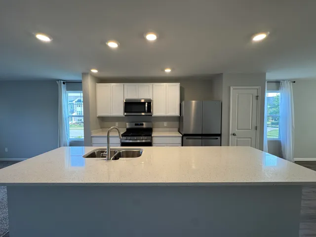 a kitchen with stainless steel appliances a refrigerator sink stove microwave and cabinets