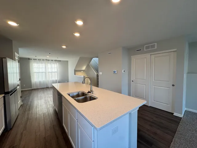 a kitchen that has a sink a stove and cabinets