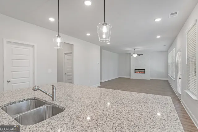 a kitchen with a sink a refrigerator and chandelier