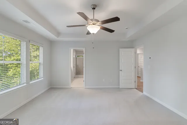 an empty room with a window and a fan