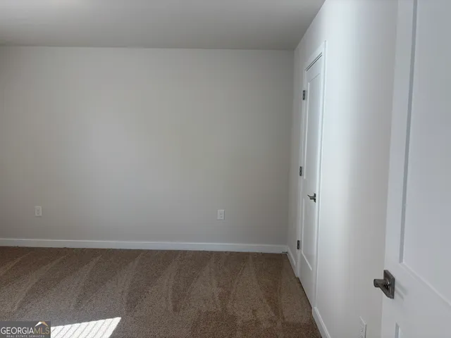 an empty room with closet and windows