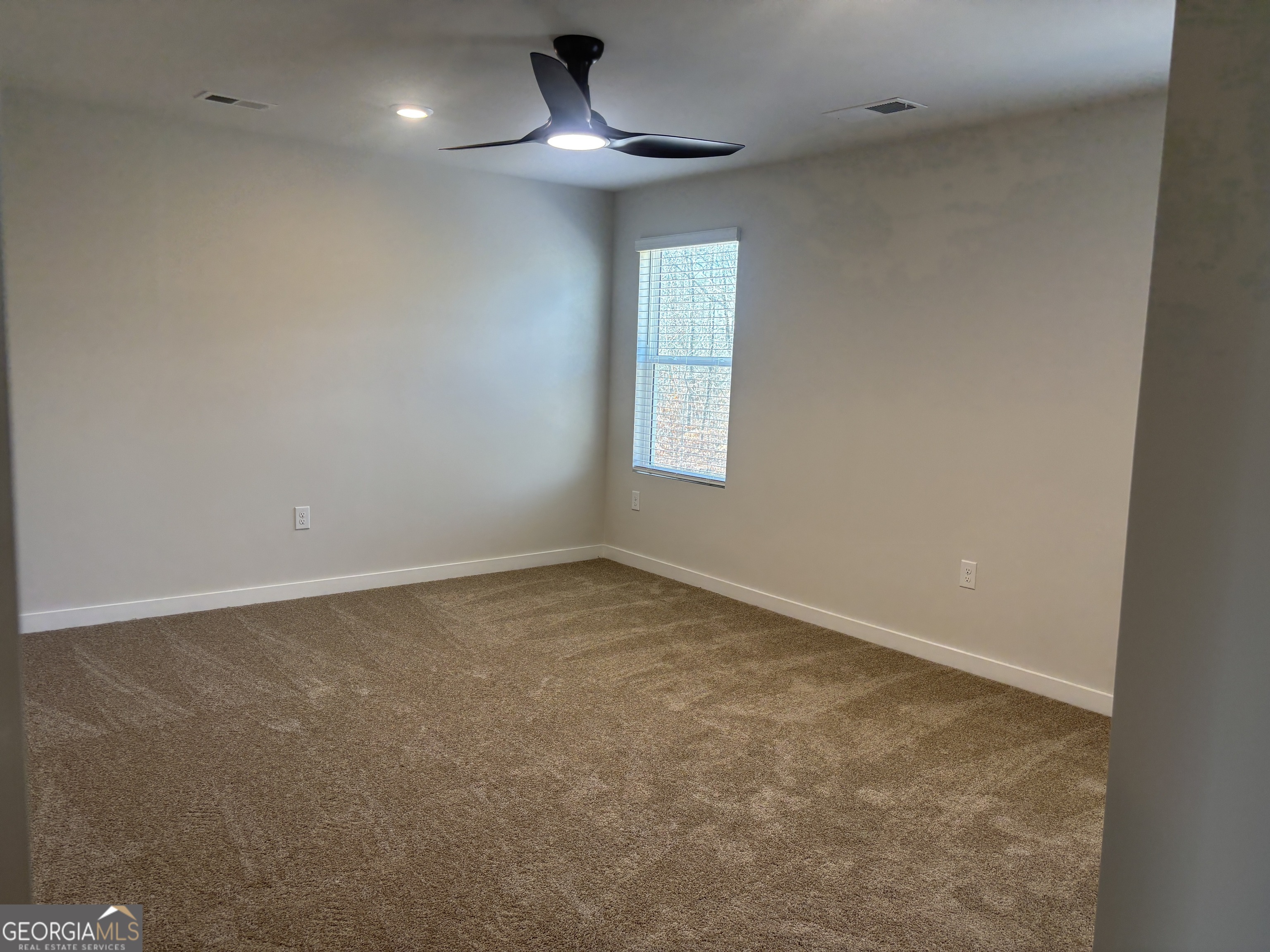 5349 Tolar Road South Fulton, GA 30213 - Photo 23 of 36 an empty room with a chandelier fan and windows