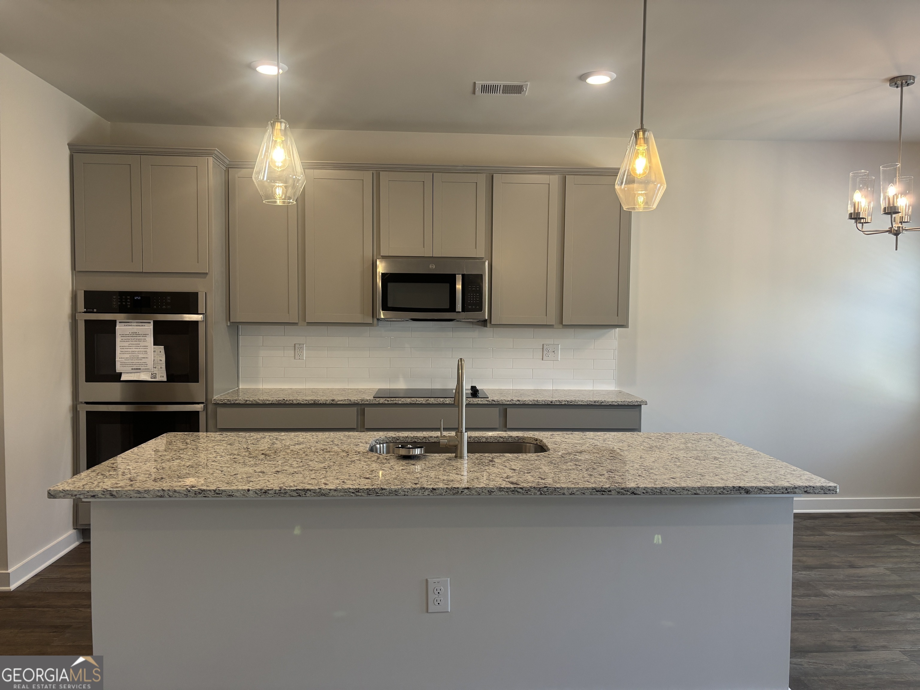 5349 Tolar Road South Fulton, GA 30213 - Photo 8 of 36 a kitchen with kitchen island granite countertop a sink and a stove top oven