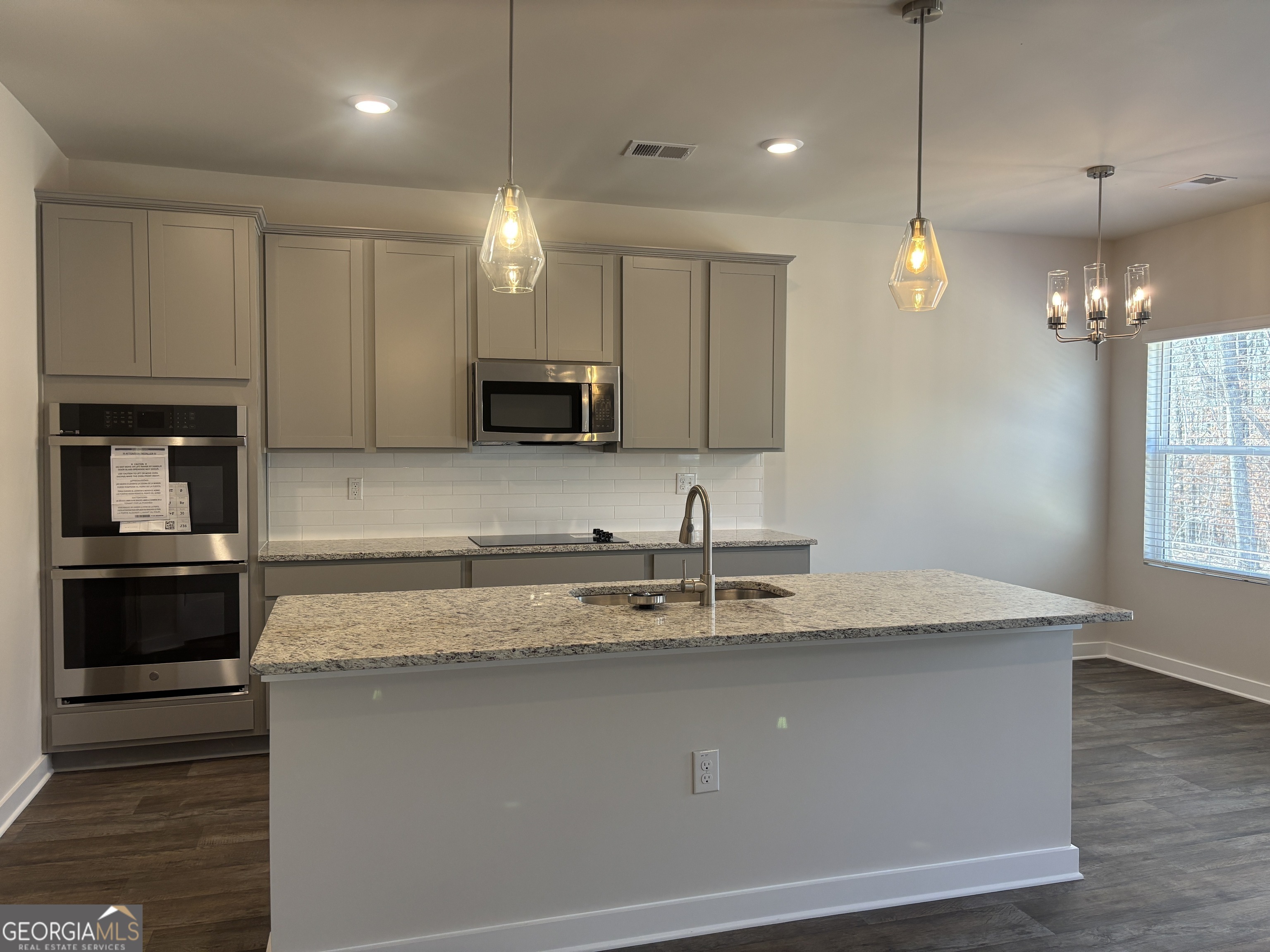5349 Tolar Road South Fulton, GA 30213 - Photo 10 of 36 a kitchen with kitchen island granite countertop a sink a counter space appliances and cabinets