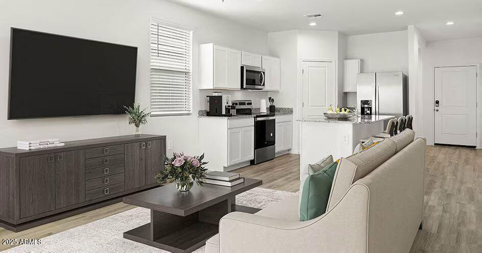 25200 North 151st Drive, Unit 4 Surprise, AZ 85387 - Photo 3 of 14 a kitchen with stainless steel appliances kitchen island granite countertop a sink a stove a microwave a dining table and chairs