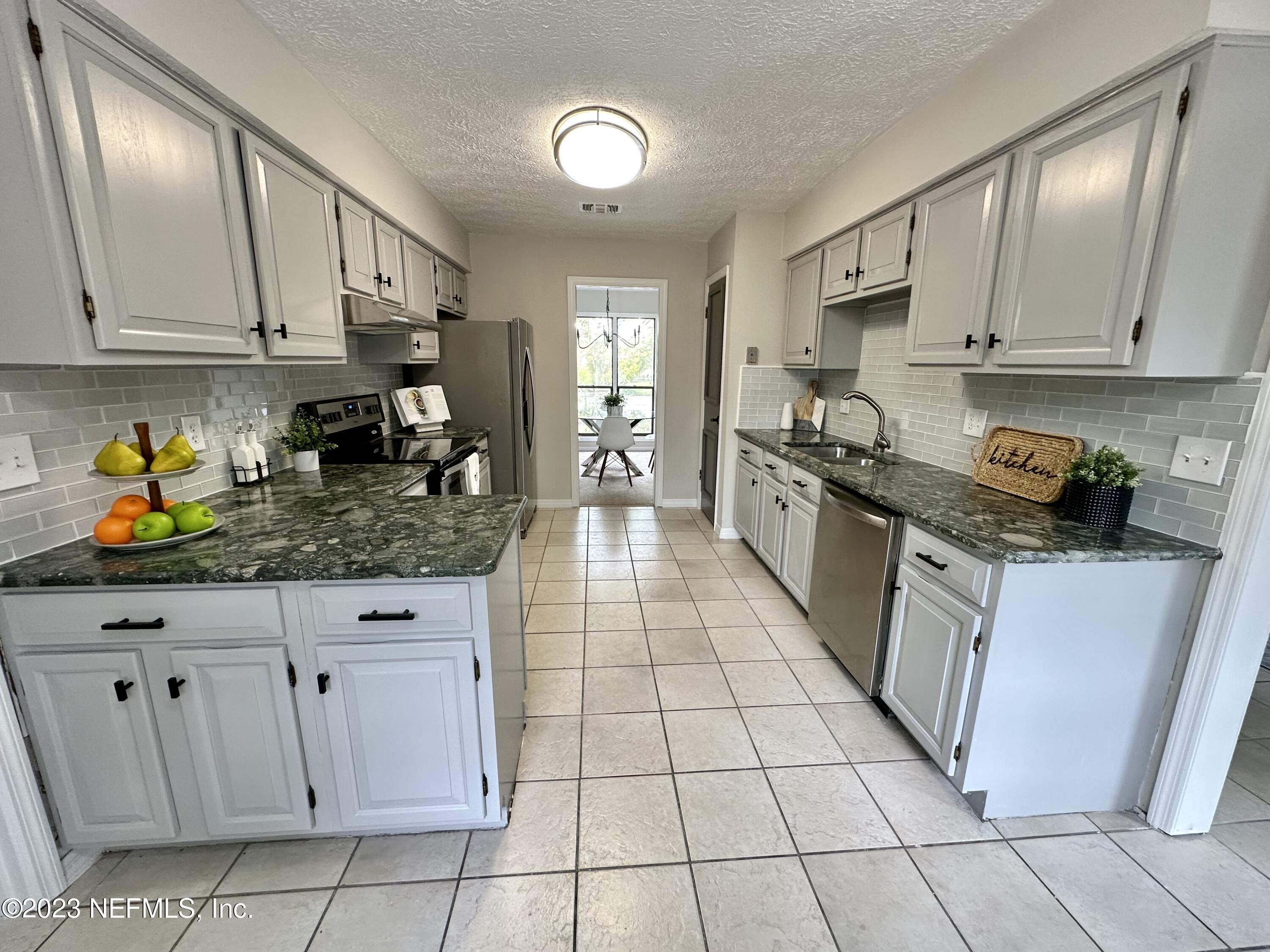 6175 Briar Forest Road West Jacksonville, FL 32277 - Photo 12 of 36 a kitchen with stainless steel appliances granite countertop a sink stove and cabinets