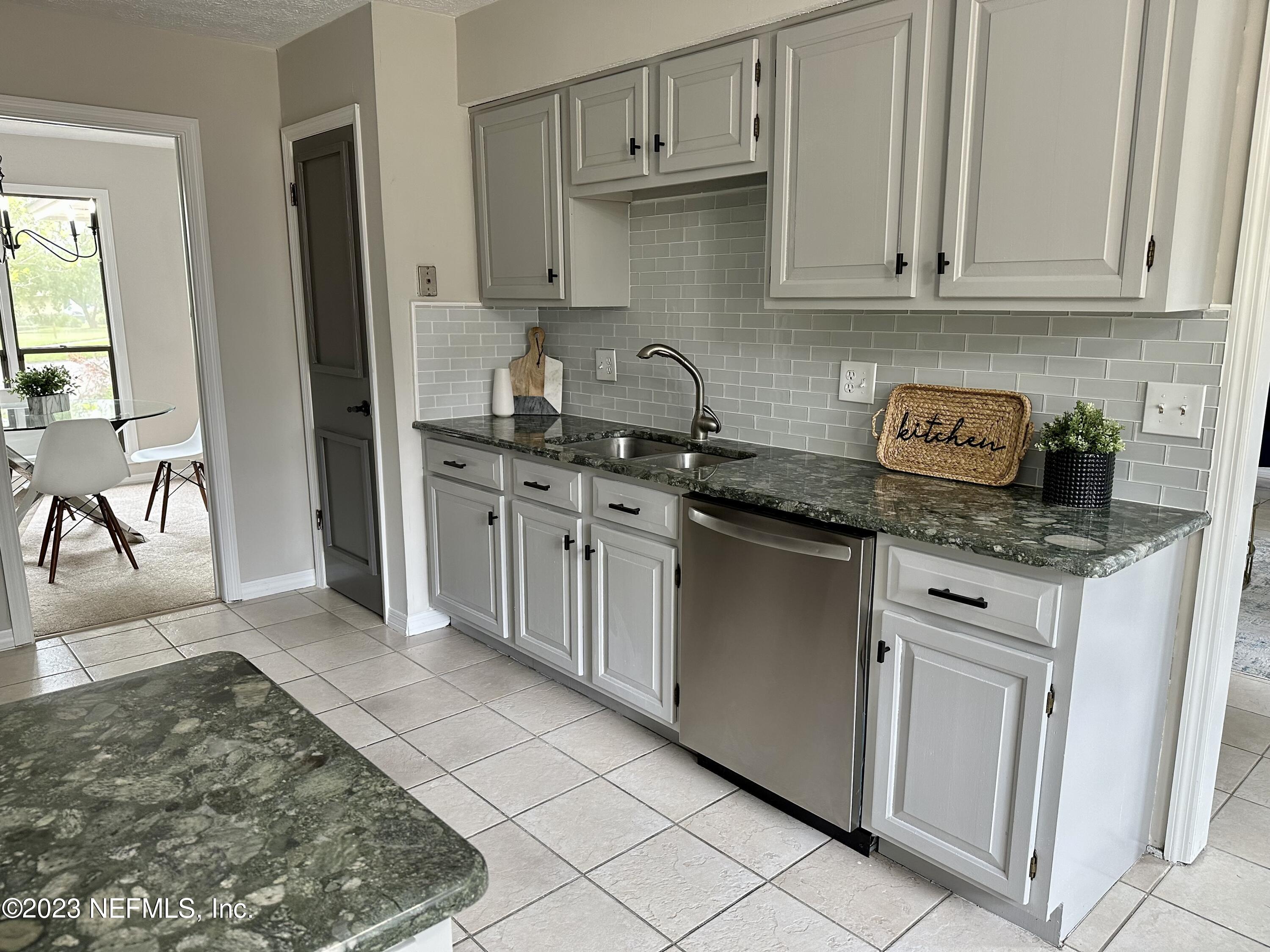 6175 Briar Forest Road West Jacksonville, FL 32277 - Photo 13 of 36 a kitchen with stainless steel appliances granite countertop a stove a sink and a refrigerator