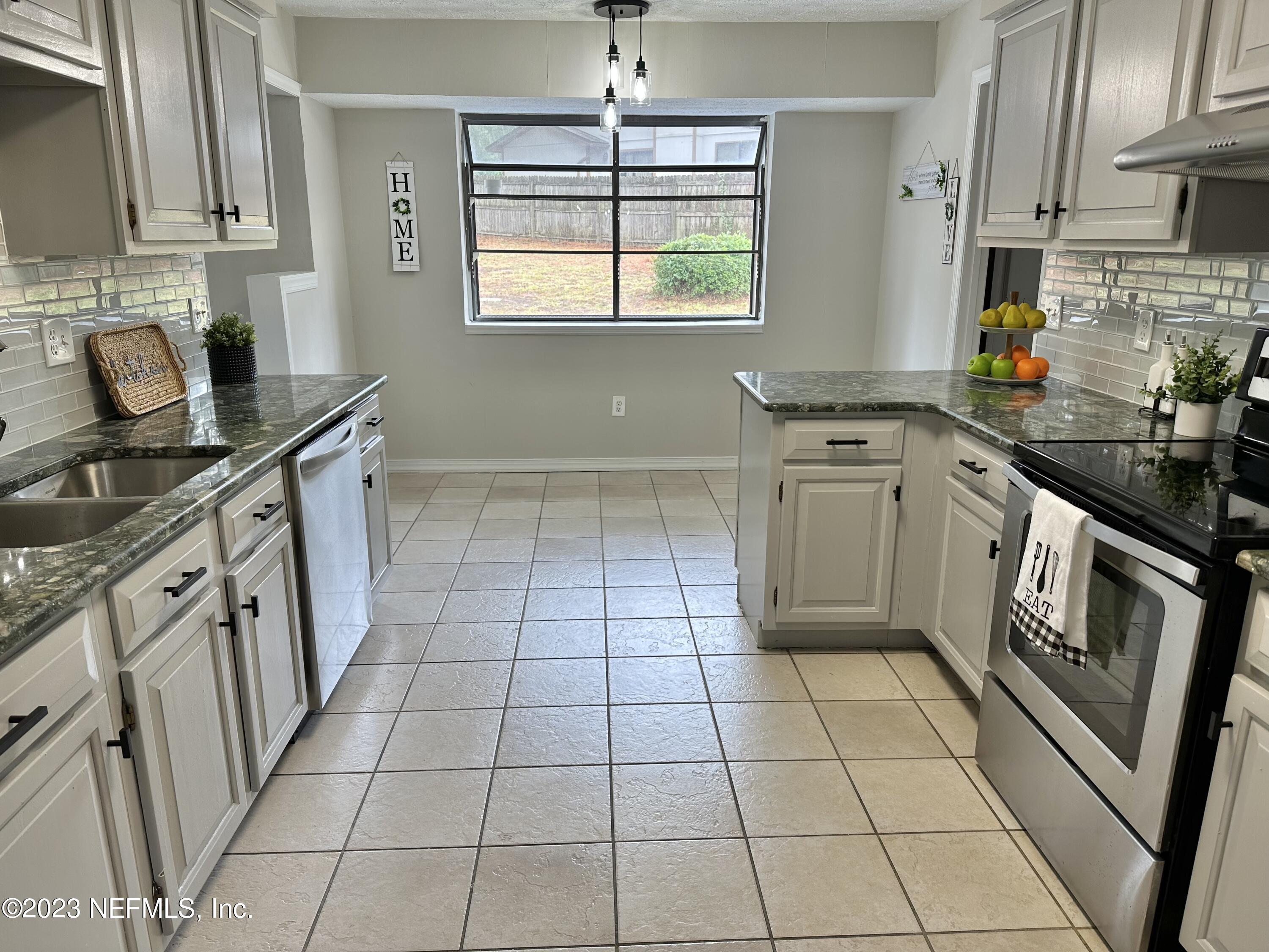 6175 Briar Forest Road West Jacksonville, FL 32277 - Photo 15 of 36 a kitchen with stainless steel appliances a sink stove and cabinets