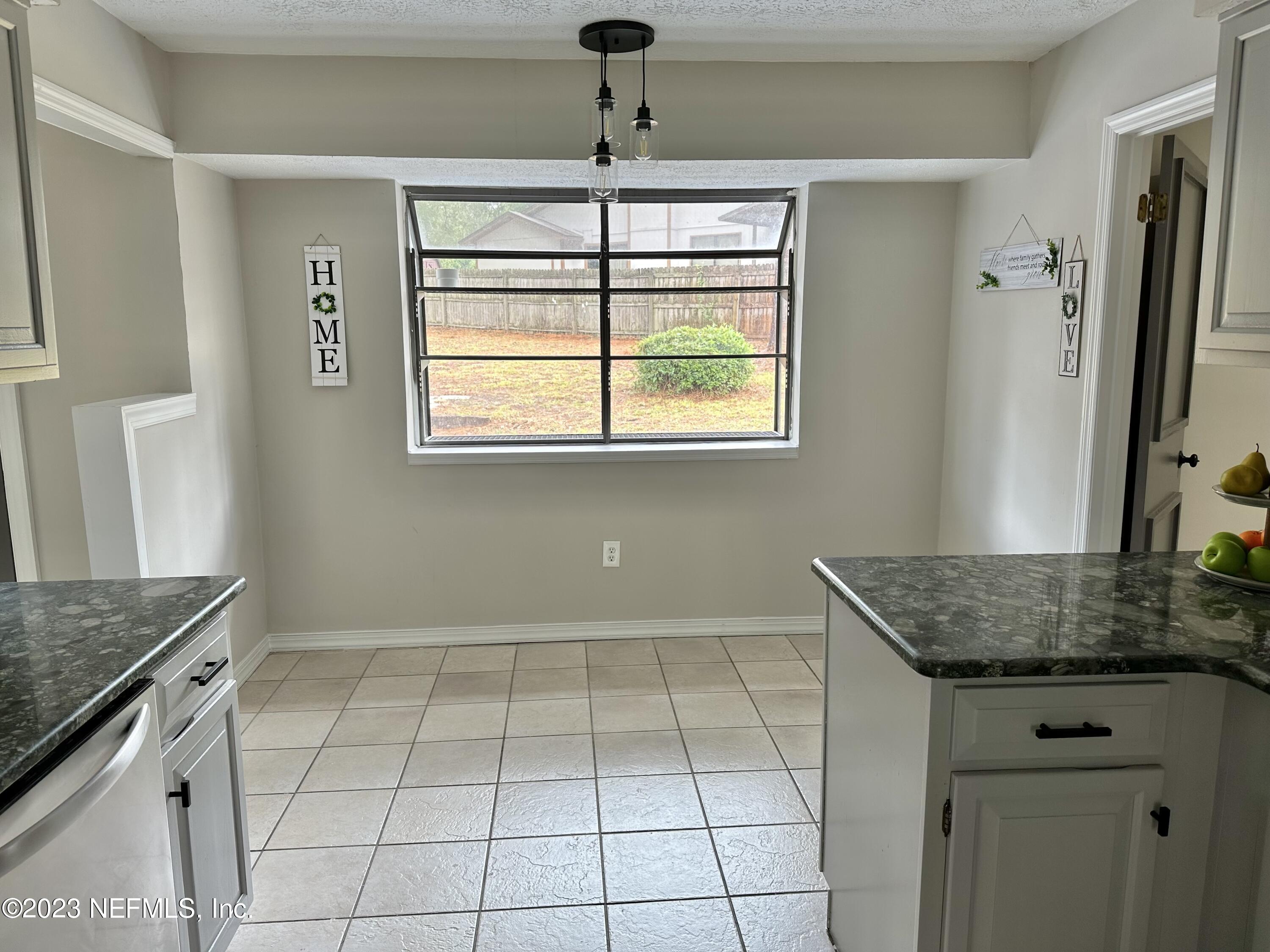 6175 Briar Forest Road West Jacksonville, FL 32277 - Photo 16 of 36 a kitchen with granite countertop a sink cabinets and window