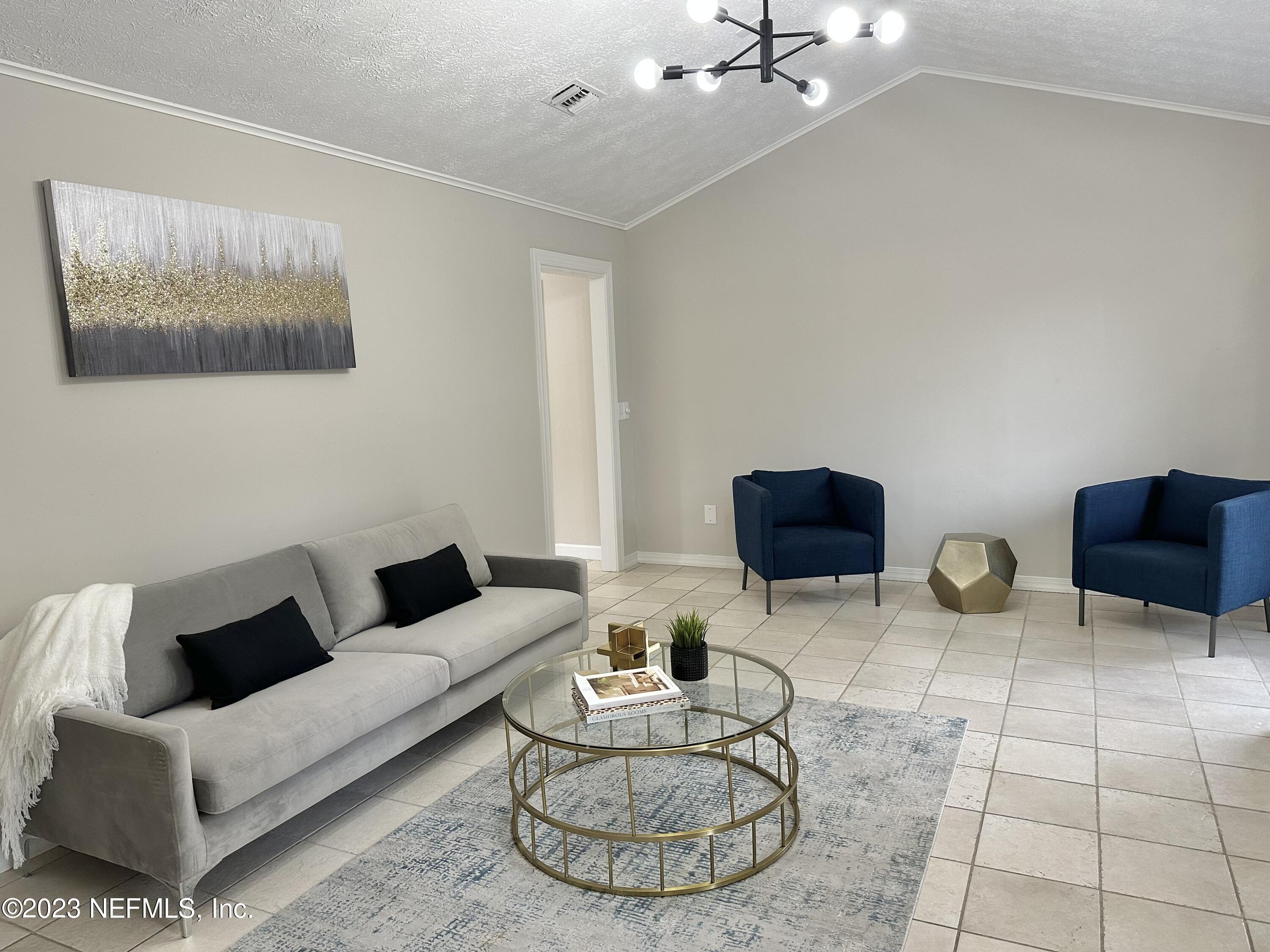 6175 Briar Forest Road West Jacksonville, FL 32277 - Photo 20 of 36 a living room with couches a rug and a painting on the wall