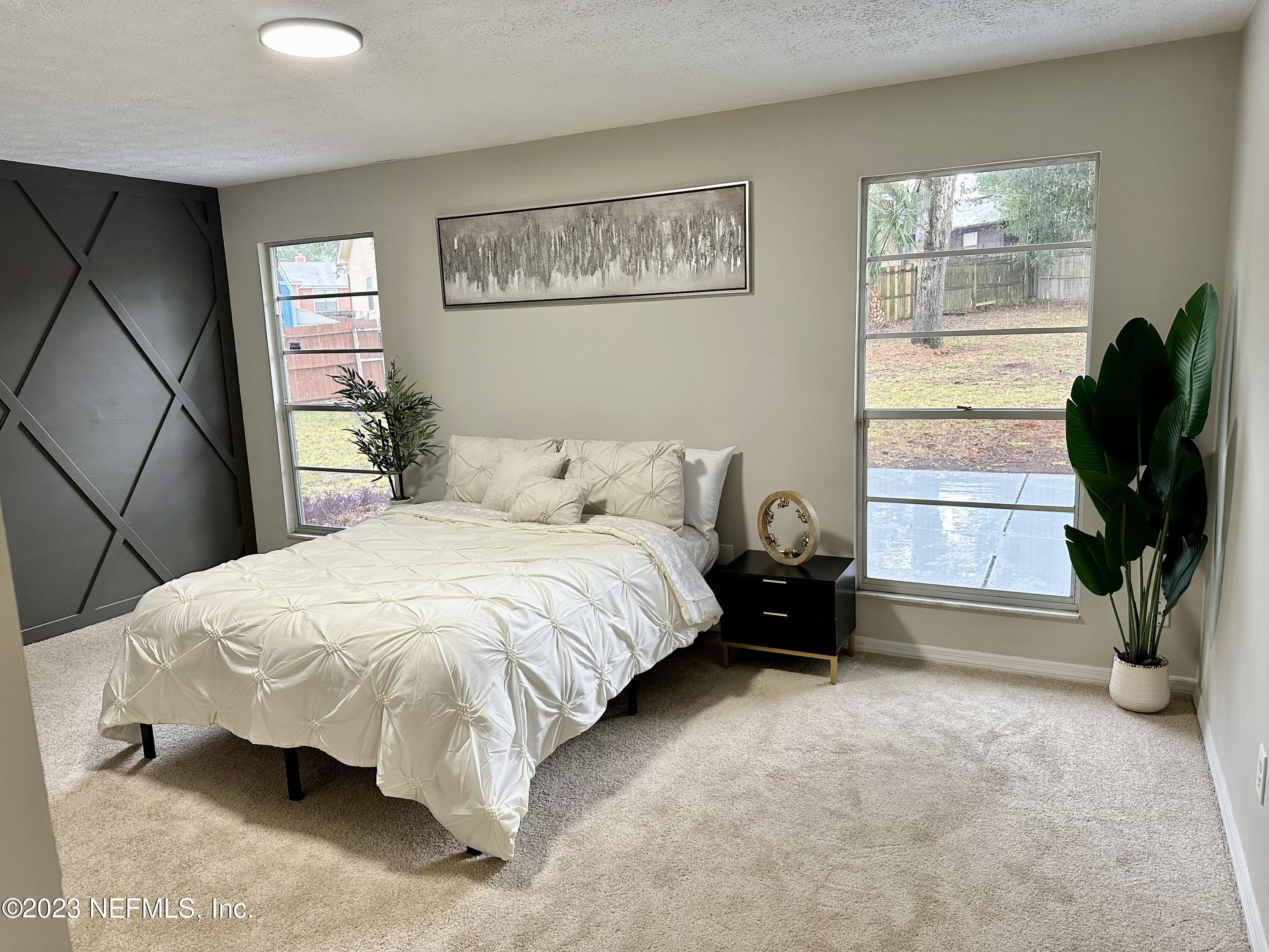 6175 Briar Forest Road West Jacksonville, FL 32277 - Photo 25 of 36 a bed sitting in a bedroom next to a window