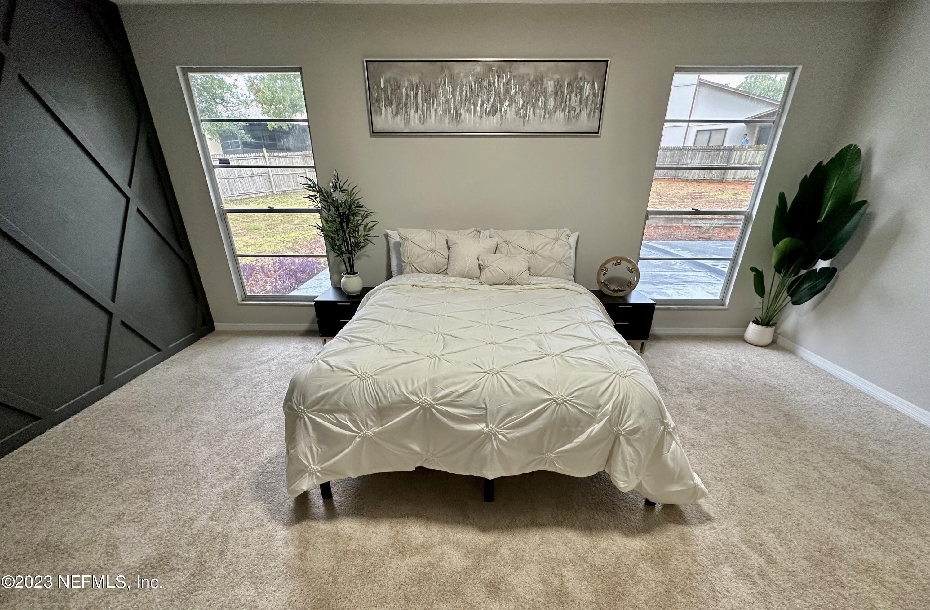 6175 Briar Forest Road West Jacksonville, FL 32277 - Photo 26 of 36 a bedroom with a bed and a flat tv screen on the dresser