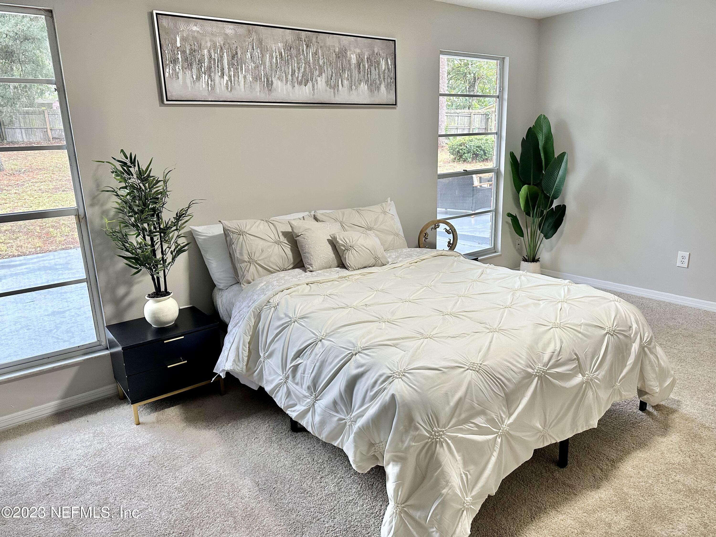 6175 Briar Forest Road West Jacksonville, FL 32277 - Photo 27 of 36 a large bed sitting in a bedroom next to a window