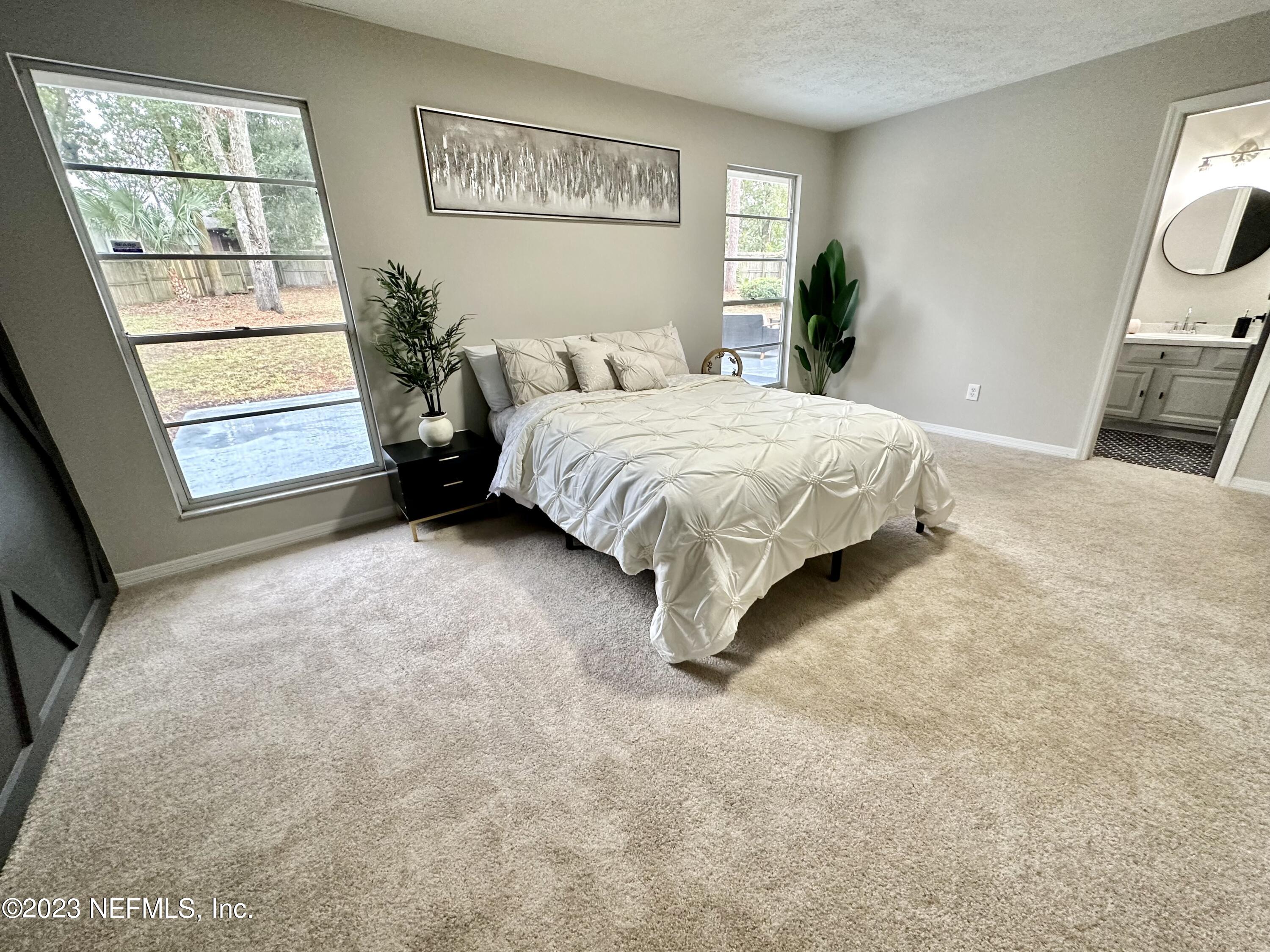 6175 Briar Forest Road West Jacksonville, FL 32277 - Photo 28 of 36 a spacious bedroom with a bed and a window