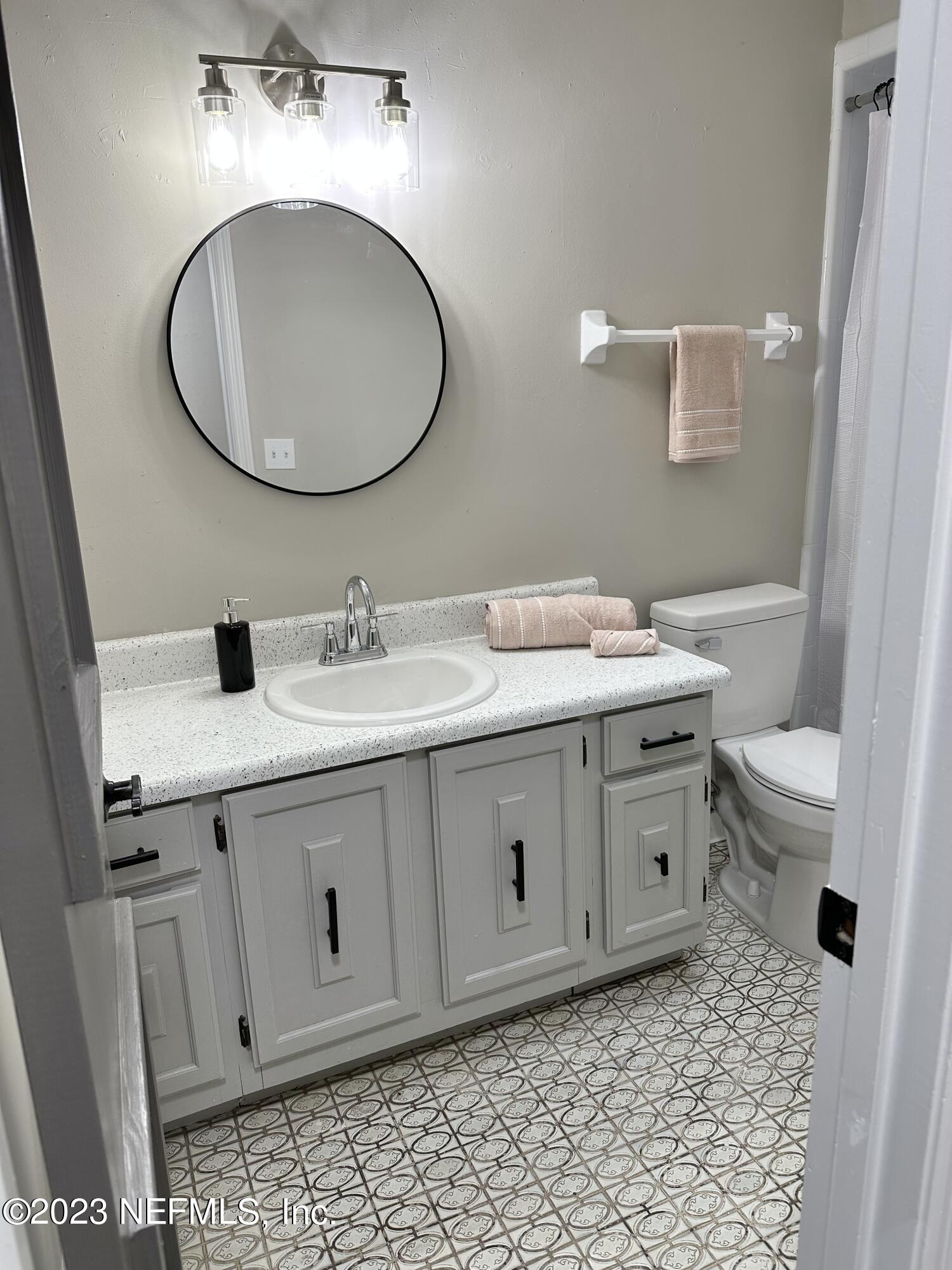 6175 Briar Forest Road West Jacksonville, FL 32277 - Photo 31 of 36 a bathroom with a sink a toilet and a mirror