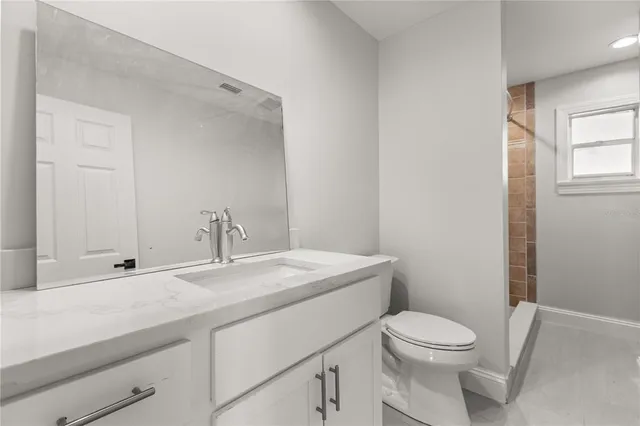 a bathroom with a toilet a sink and mirror