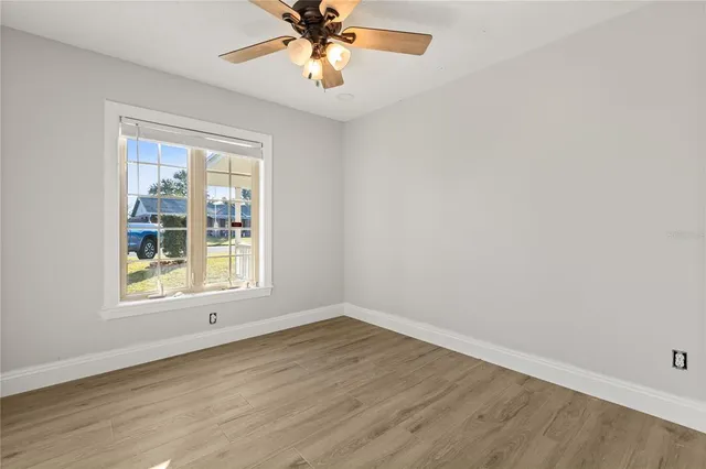 an empty room with a window and a fan