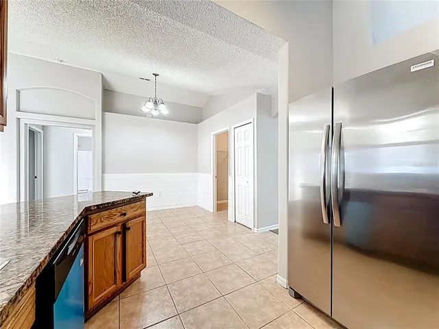 a kitchen with granite countertop a refrigerator and a sink