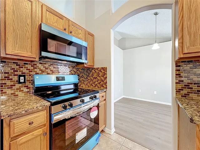 a kitchen with stainless steel appliances wooden cabinets and a stove top oven